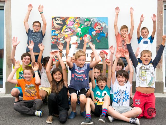 groupe d'enfants devant fresque colorée